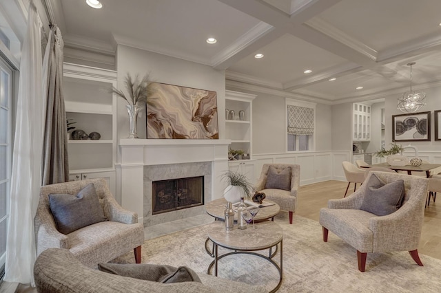 living area with beam ceiling, ornamental molding, and a fireplace