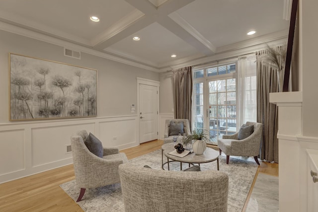 sitting room featuring coffered ceiling, ornamental molding, light hardwood / wood-style floors, and beam ceiling