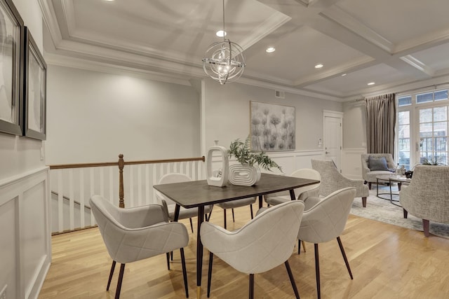 dining space featuring coffered ceiling, crown molding, an inviting chandelier, and light hardwood / wood-style floors