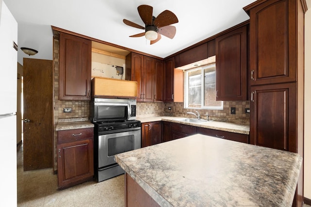 kitchen with sink, decorative backsplash, stainless steel appliances, and ceiling fan