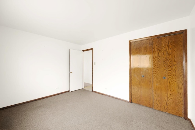 unfurnished bedroom featuring light colored carpet and a closet