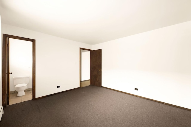 unfurnished bedroom with a baseboard radiator, connected bathroom, and carpet