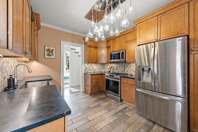 kitchen with dark countertops, appliances with stainless steel finishes, backsplash, and a sink