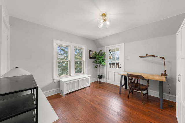 office space with baseboards, vaulted ceiling, hardwood / wood-style flooring, and radiator