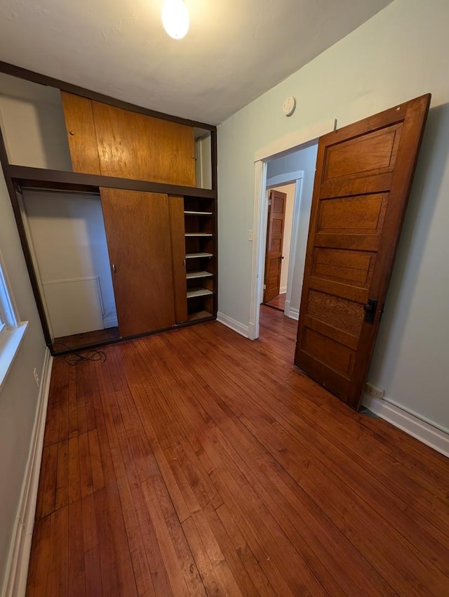 unfurnished bedroom featuring hardwood / wood-style flooring and a closet