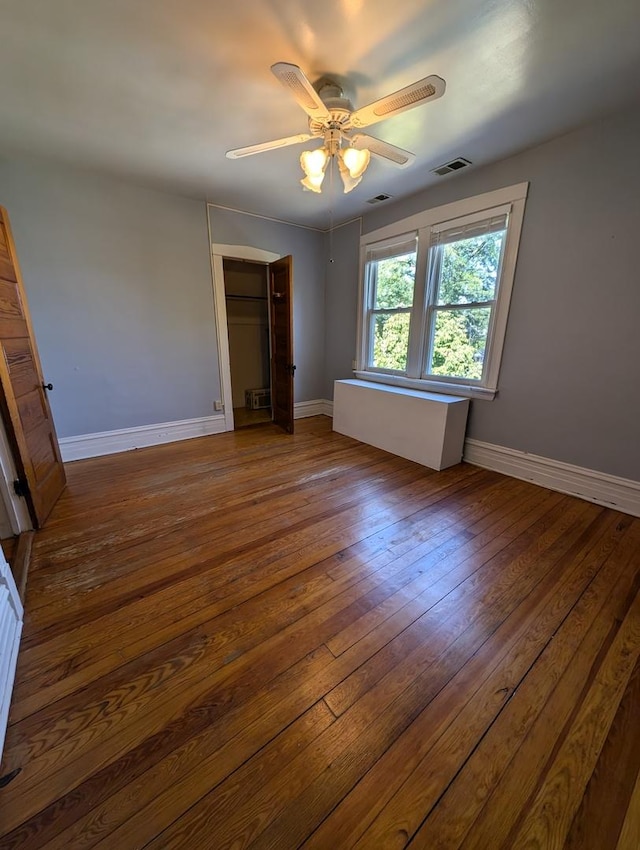 unfurnished bedroom featuring dark wood-type flooring and ceiling fan