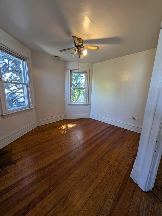 spare room with dark hardwood / wood-style flooring and ceiling fan