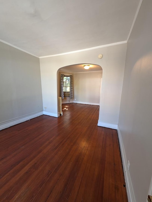 spare room with dark wood-type flooring and ornamental molding