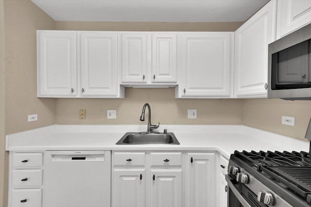 kitchen with stainless steel appliances, white cabinetry, and sink