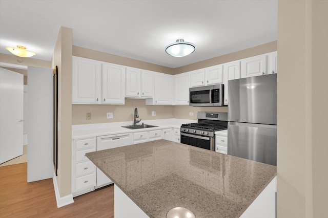 kitchen featuring light stone countertops, appliances with stainless steel finishes, sink, and white cabinets