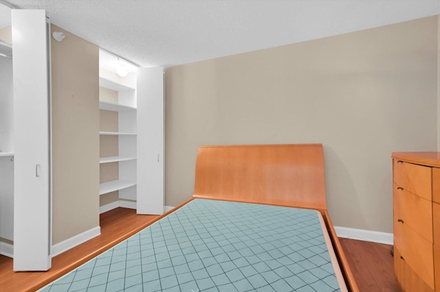 unfurnished bedroom with hardwood / wood-style floors and a textured ceiling