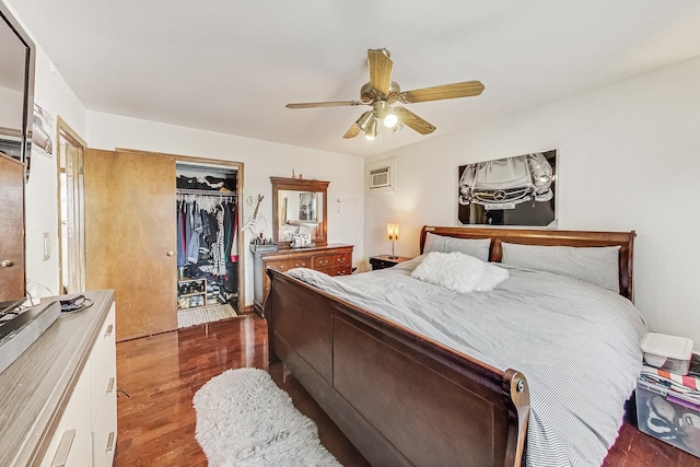 bedroom with dark wood-type flooring, ceiling fan, a wall unit AC, and a closet