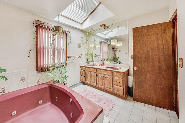 bathroom with tile patterned floors, a tub to relax in, a skylight, and vanity