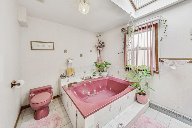 bathroom with tiled tub, a skylight, a baseboard radiator, tile patterned floors, and toilet