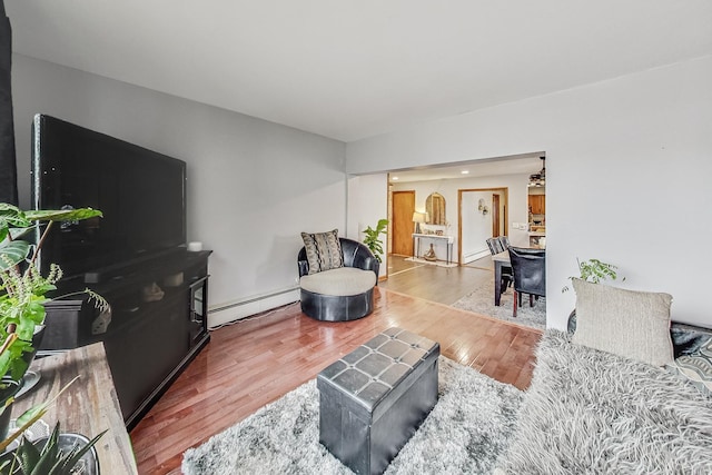 living room with wood-type flooring and a baseboard heating unit