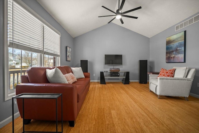 living room with lofted ceiling, hardwood / wood-style flooring, and ceiling fan