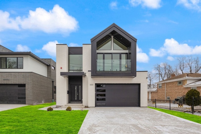 modern home with a garage, brick siding, fence, driveway, and a front lawn