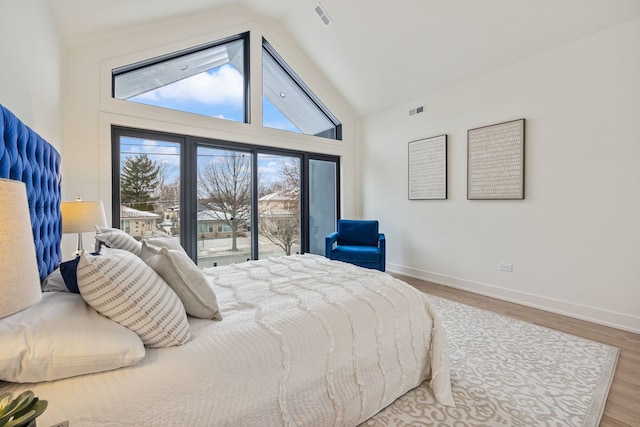 bedroom featuring access to outside, wood finished floors, visible vents, and baseboards