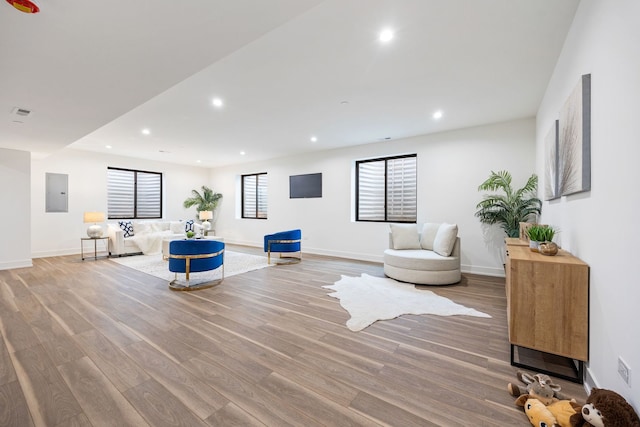 sitting room with electric panel, wood finished floors, and recessed lighting