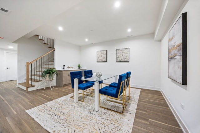 dining space with visible vents, baseboards, wood finished floors, stairs, and recessed lighting