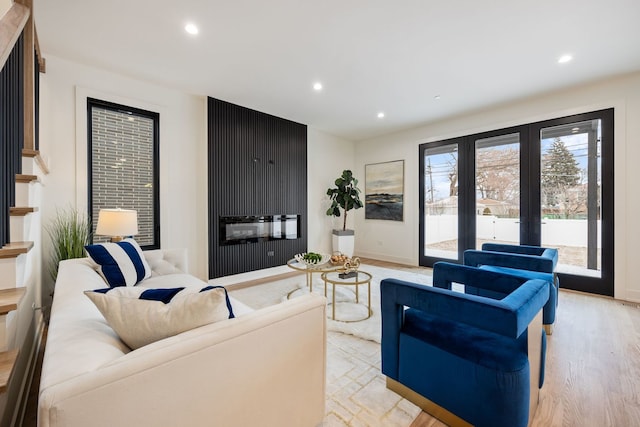 living area featuring recessed lighting, baseboards, stairs, french doors, and light wood-type flooring