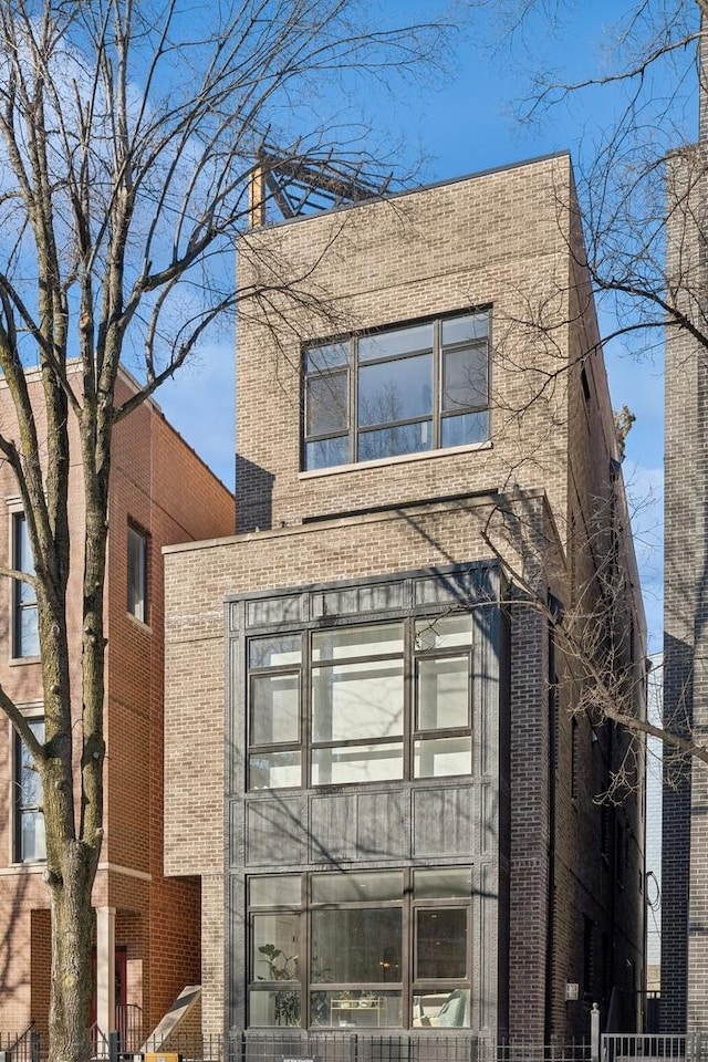 view of front of property with brick siding and fence