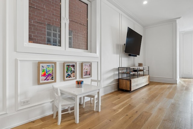 interior space featuring baseboards, light wood-type flooring, and crown molding