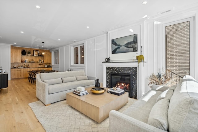 living room featuring recessed lighting, visible vents, and light wood finished floors