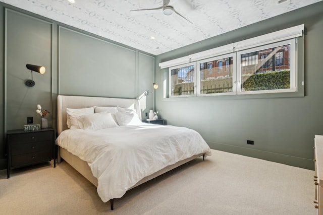 bedroom with light carpet, baseboards, and a ceiling fan