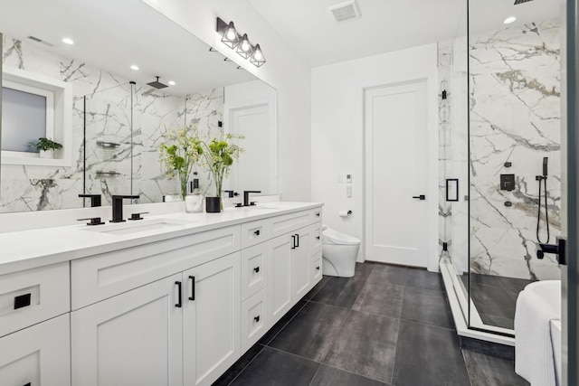 full bathroom featuring tile walls, a marble finish shower, visible vents, toilet, and a sink