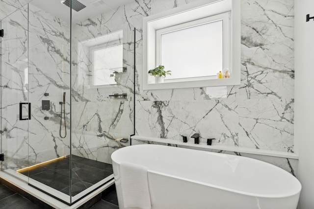 full bath featuring a soaking tub, tile walls, a marble finish shower, and stone wall