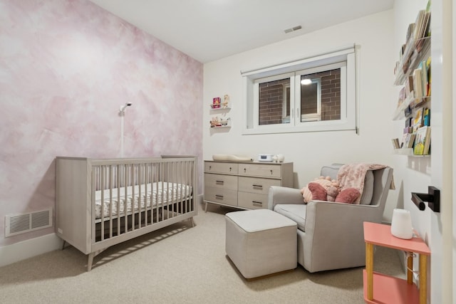 bedroom with light carpet, visible vents, and a crib