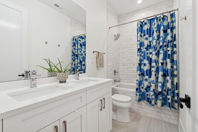 full bath with double vanity, tiled shower / bath, visible vents, and a sink