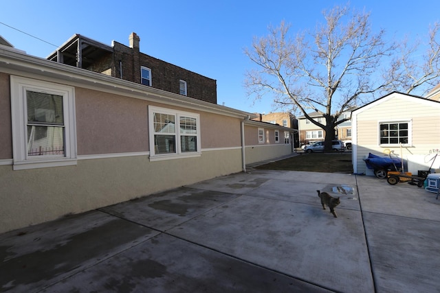 view of side of property featuring a patio area and stucco siding