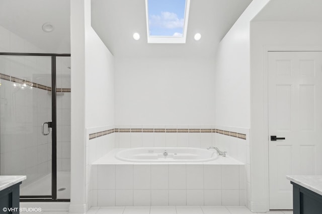 full bathroom with a skylight, a garden tub, a stall shower, and vanity