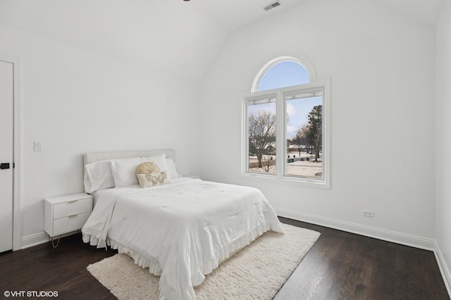 bedroom featuring lofted ceiling, visible vents, baseboards, and dark wood-type flooring