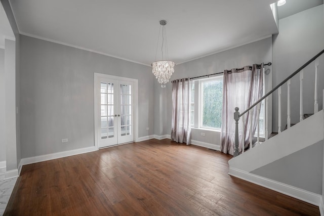 interior space with crown molding, hardwood / wood-style floors, an inviting chandelier, and french doors