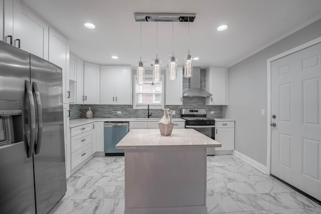 kitchen featuring wall chimney exhaust hood, white cabinetry, decorative light fixtures, a center island, and stainless steel appliances