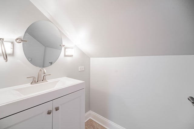 bathroom featuring vanity and lofted ceiling