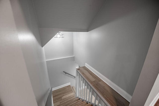 stairway with hardwood / wood-style flooring and vaulted ceiling