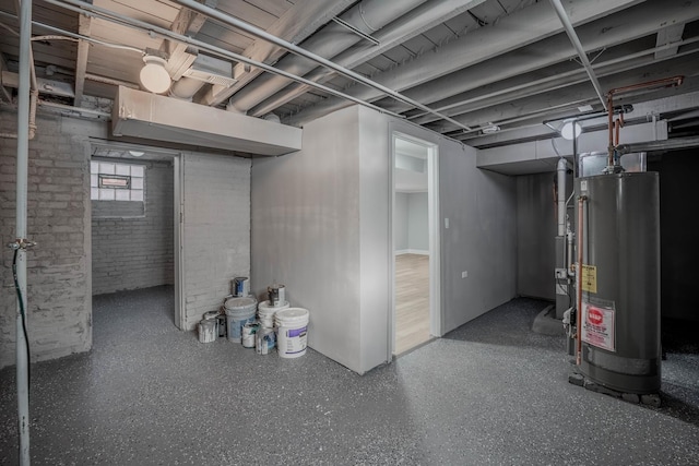 basement featuring brick wall and water heater