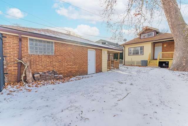 snow covered property featuring central AC unit