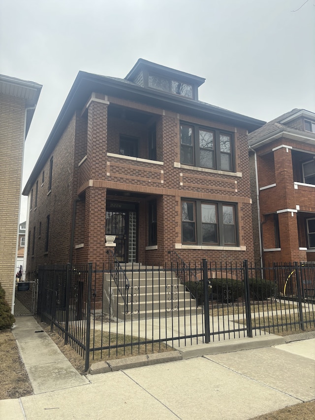 american foursquare style home featuring a fenced front yard, a gate, and brick siding