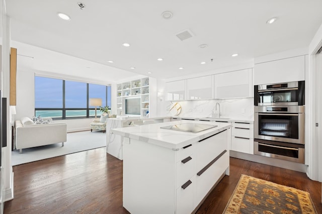 kitchen featuring double oven, black electric cooktop, sink, and white cabinets