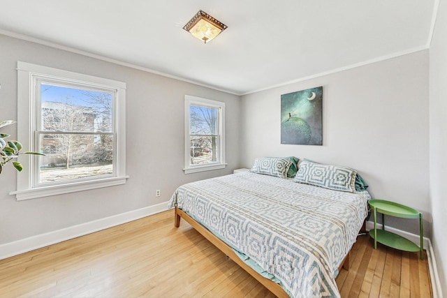 bedroom featuring baseboards, hardwood / wood-style floors, and ornamental molding