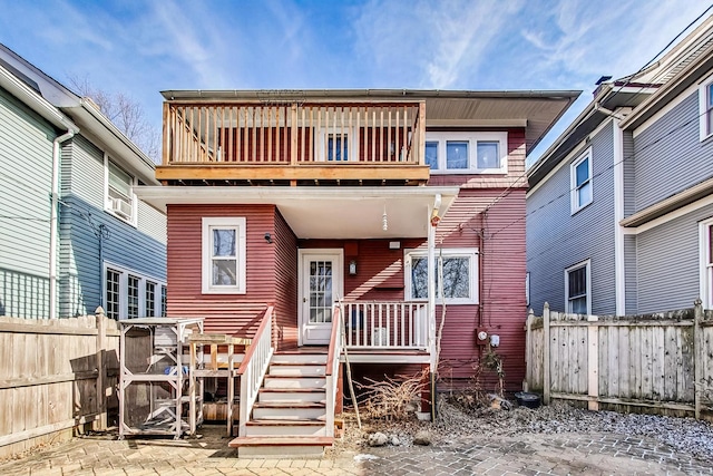 back of house featuring a fenced backyard and a balcony