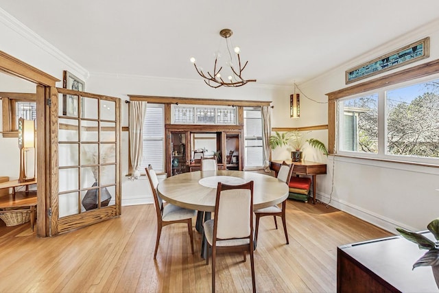 dining room featuring ornamental molding, an inviting chandelier, and light wood-style floors