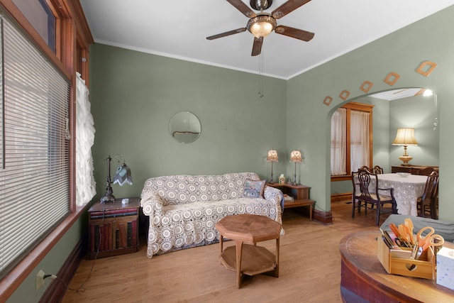 living room featuring crown molding, ceiling fan, and light hardwood / wood-style floors