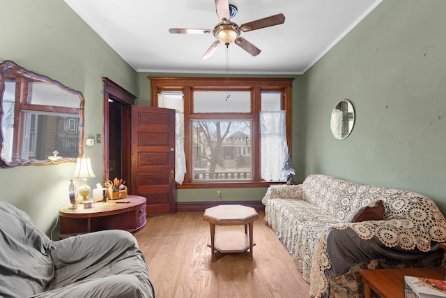 living room featuring crown molding, hardwood / wood-style floors, and ceiling fan