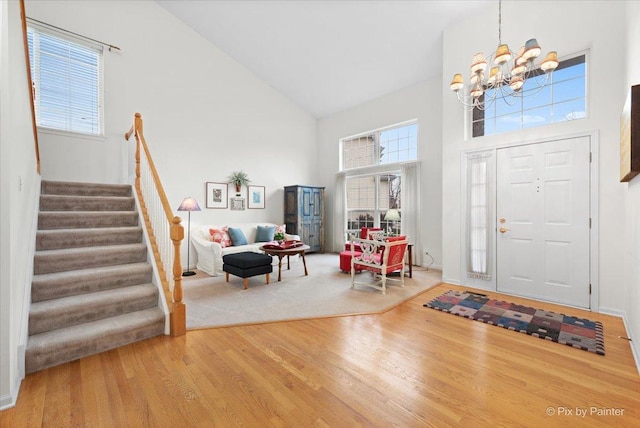 entrance foyer with hardwood / wood-style flooring, a chandelier, and high vaulted ceiling